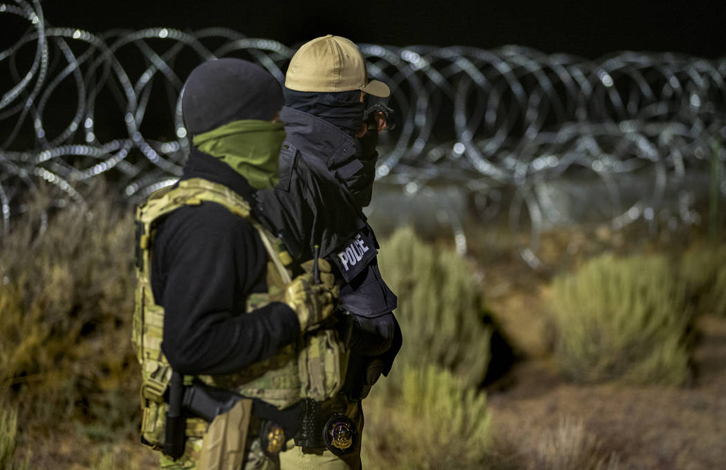 Security personnel stand along the fence line near the back gate of Area 51 in homage to the or ...