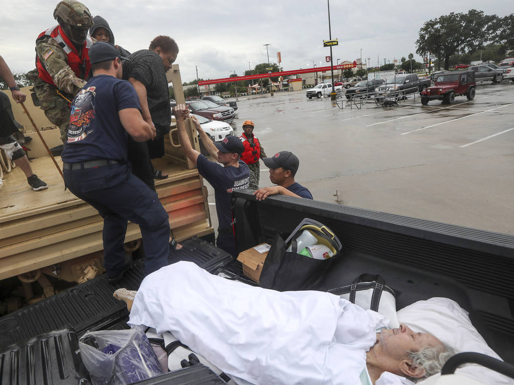 Dwain Kaufman, right, waits for his wife as she is helped into the back of a family member's tr ...