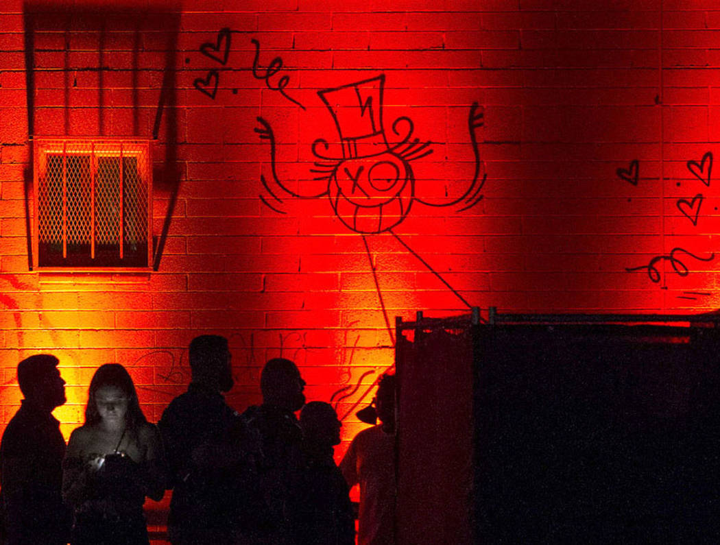 Attendees walk through an illuminated walkway during the first day of the Life is Beautiful fes ...