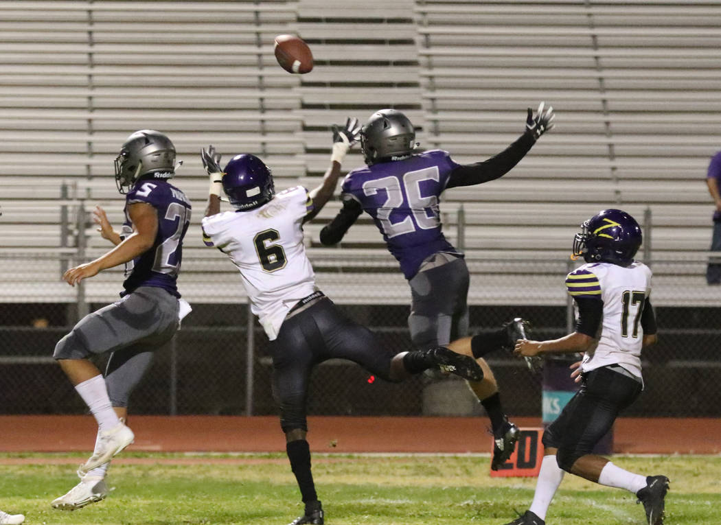 Silverado High's running back Breven Palpallatoc (23) and Vance Lyman (26) defend Durango High' ...