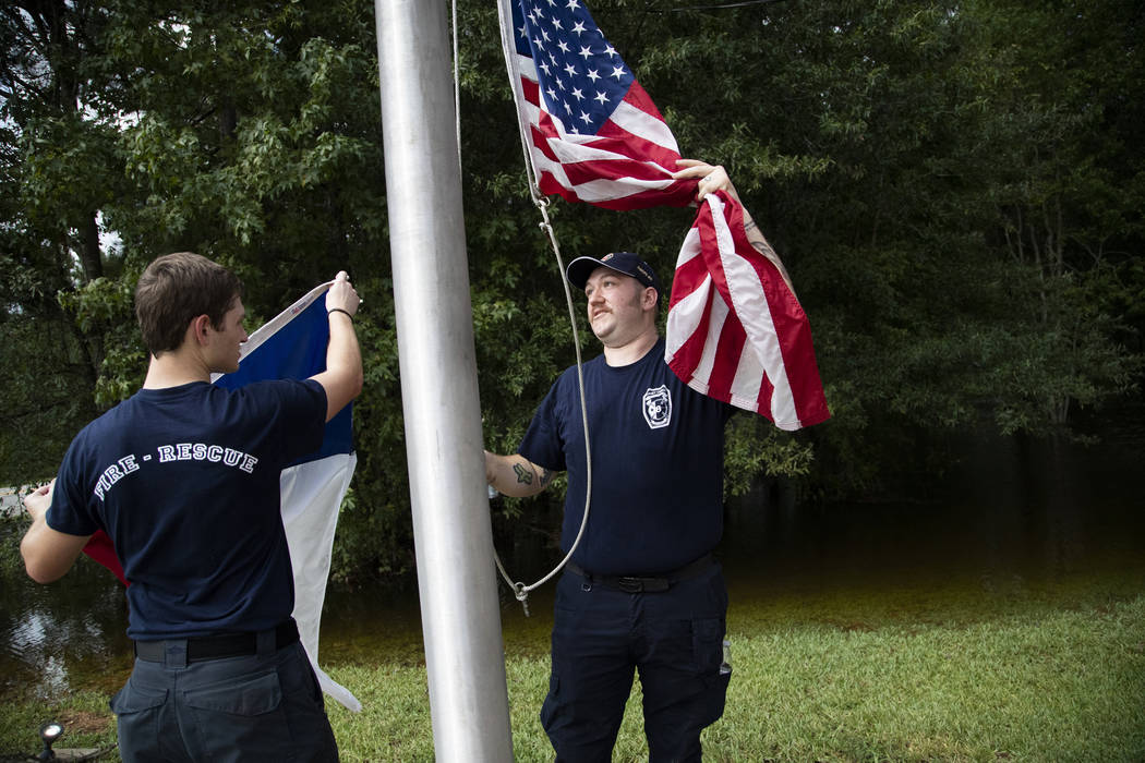 Caney Creek Fire Department firefighters Avery Aultman, 21, left, Luke Hancock, 24, right, rais ...