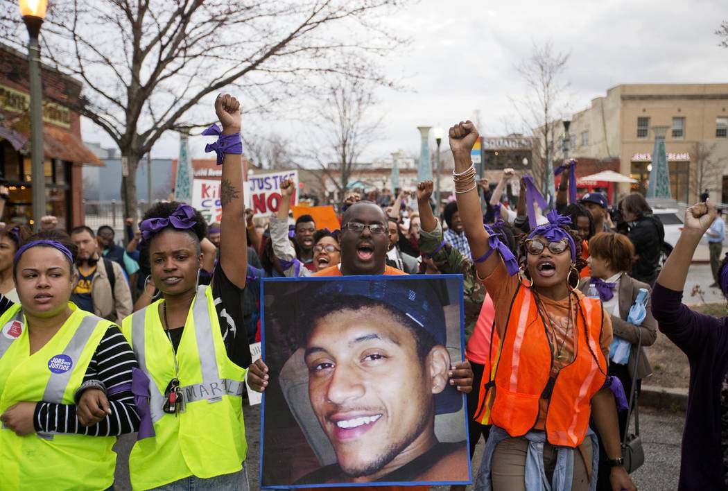 FILE - In this March 11, 2015 file photo, Brandon Marshall carries a photo of Anthony Hill as p ...