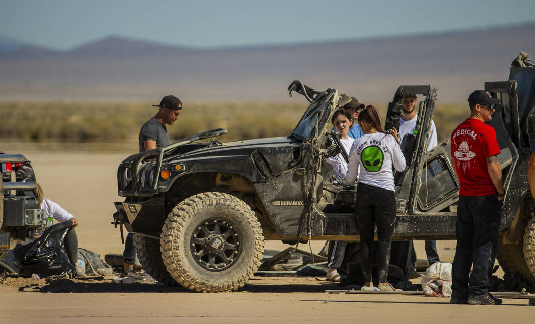 Festivalgoers connected to the scene of a vehicle rollover are assisted by emergency and medica ...