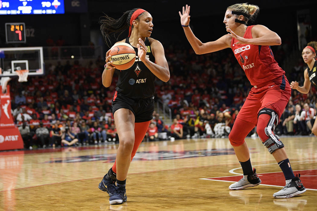 Las Vegas Aces center A'ja Wilson, left, dribbles the ball against Washington Mystics forward E ...