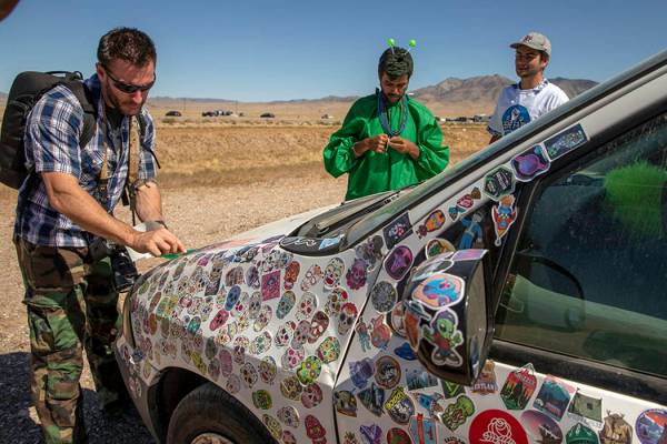 Festivalgoers add stickers to a car parked on the frontage road during the Alienstock festival ...