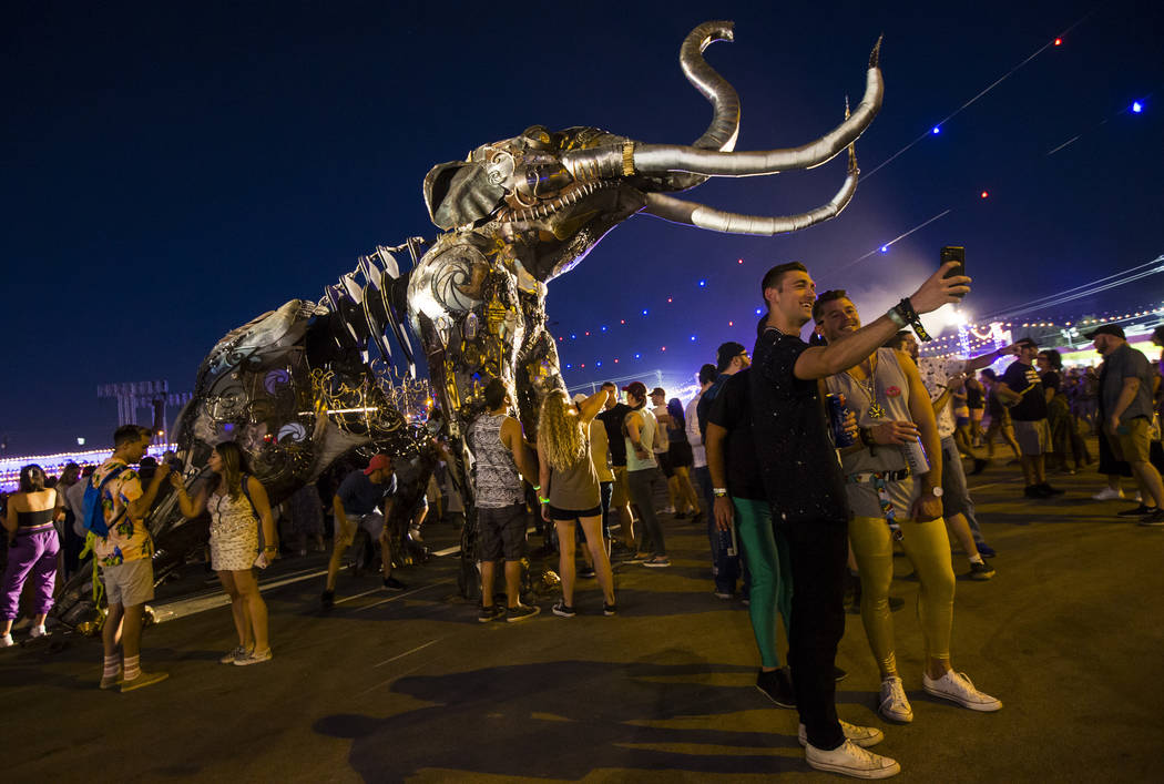 Attendees take pictures by the Monumental Mammoth sculpture, created by Tahoe Mack, during day ...