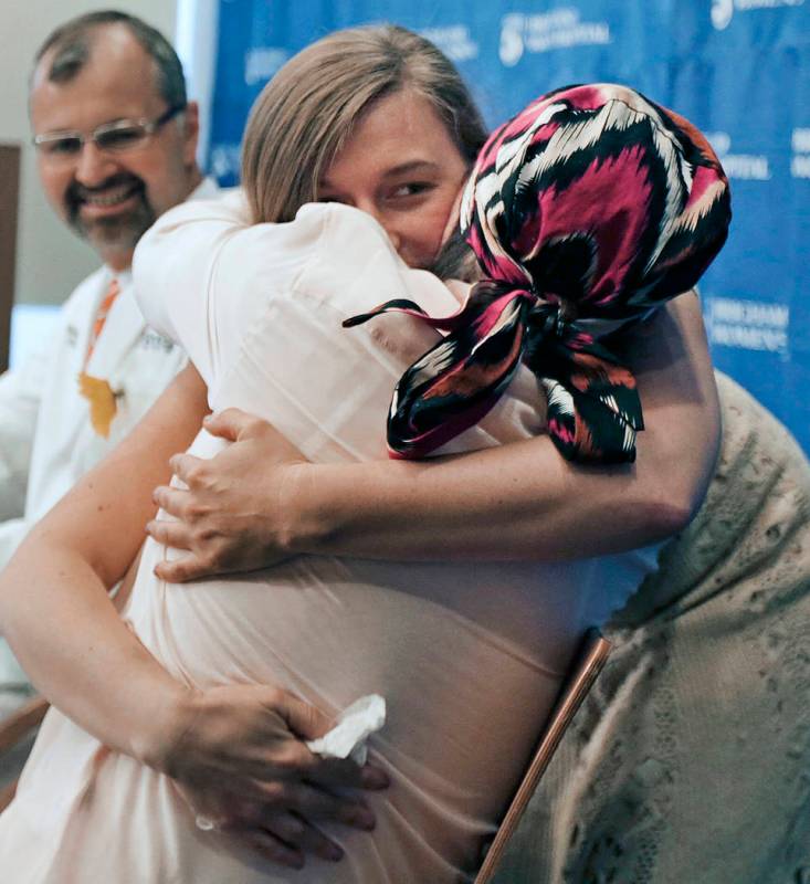 Marinda Righter, daughter of face donor Cheryl Denelli-Righter, embraces recipient Carmen Bland ...