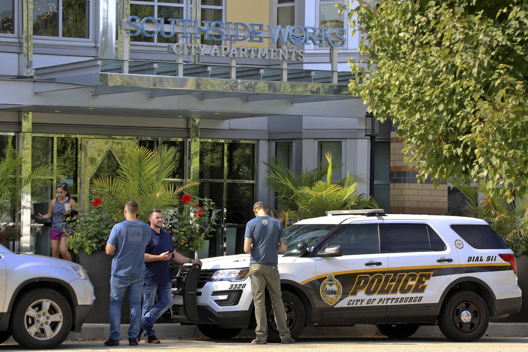 Pittsburgh police investigators gather outside an apartment building on the city's South Side w ...