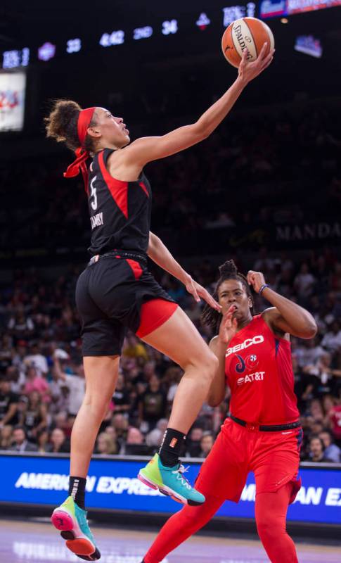 Las Vegas Aces forward Dearica Hamby (5) drives past Washington Mystics guard Ariel Atkins (7) ...