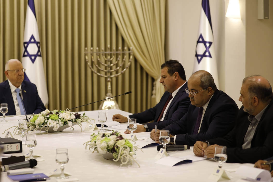 Israeli President Reuven Rivlin, left, listens to members of the Joint List Ayman Odeh, third r ...