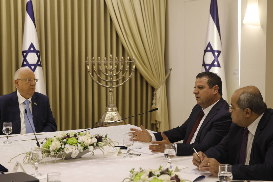 Israeli President Reuven Rivlin, left, listens to members of the Joint List Ayman Odeh, second ...