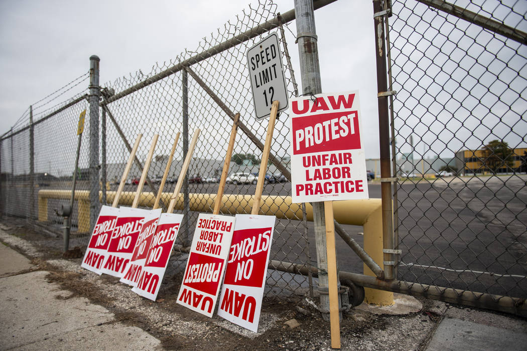 United Auto Workers protest signs lean against the fence at GM Powertrain in Bay City, Mich., o ...