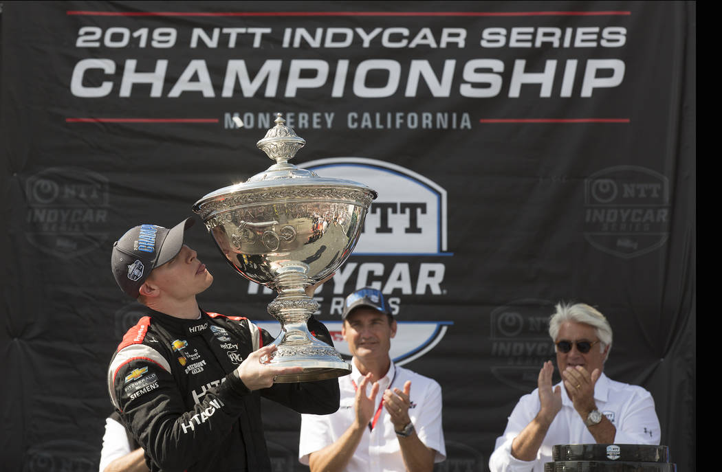 Josef Newgarden, left, kisses the trophy after winning the championship after an IndyCar auto r ...