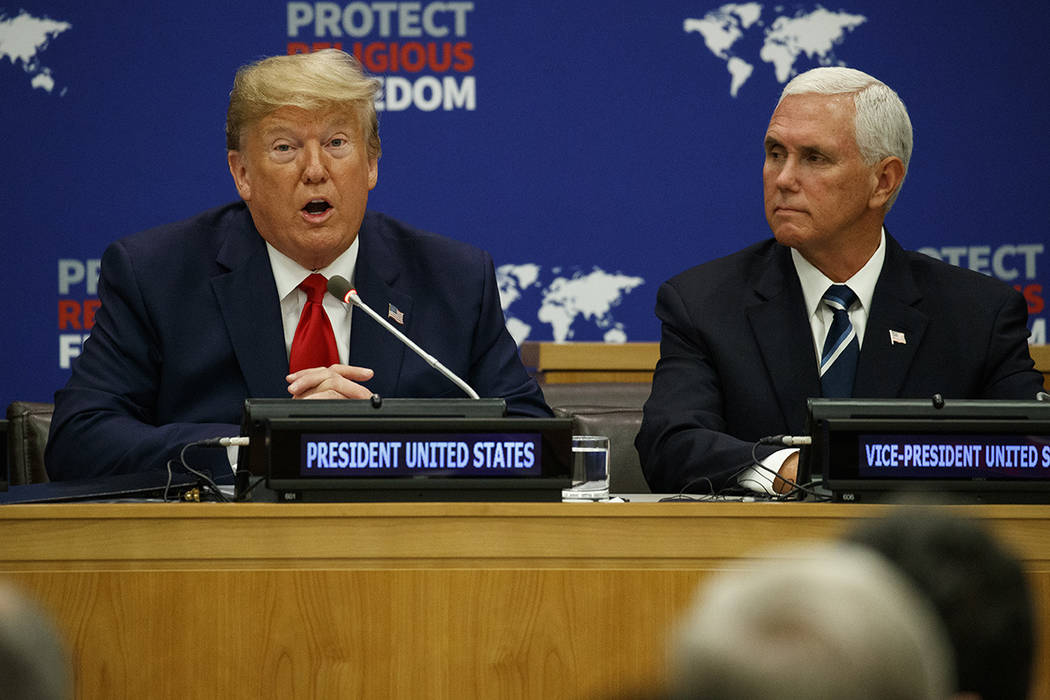 Vice President Mike Pence listens as President Donald Trump speaks at an event on religious fre ...