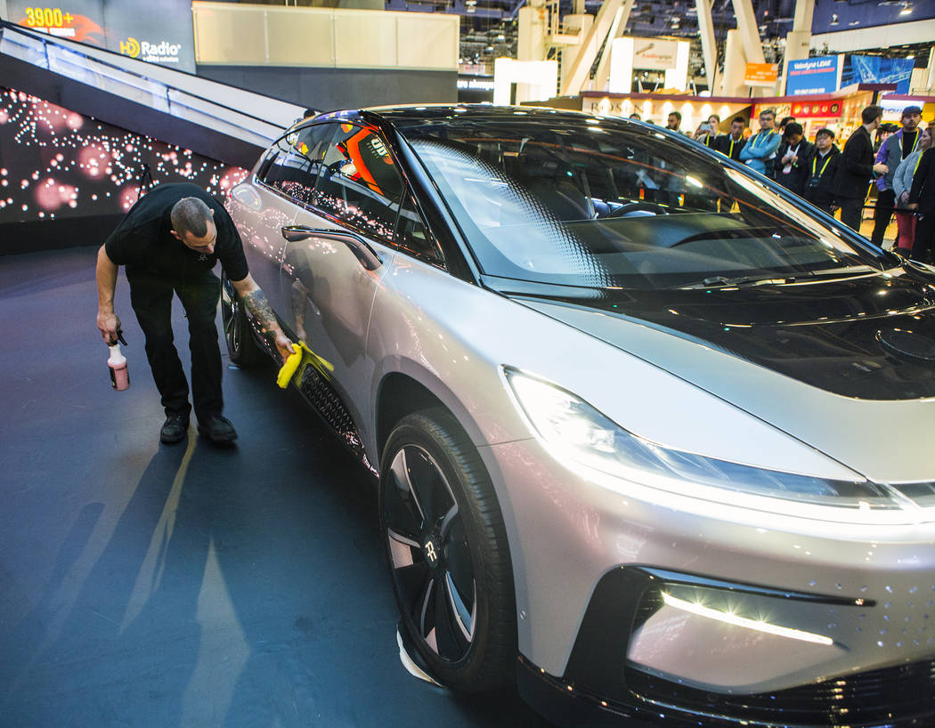 A man wipes down Faraday Future's new concept car during CES 2017 in the Las Vegas Convention C ...