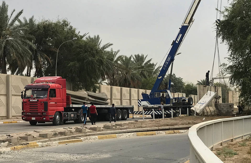 In this Tuesday, May 28, 2019 photo, Iraqi security forces remove concrete blast walls at the G ...