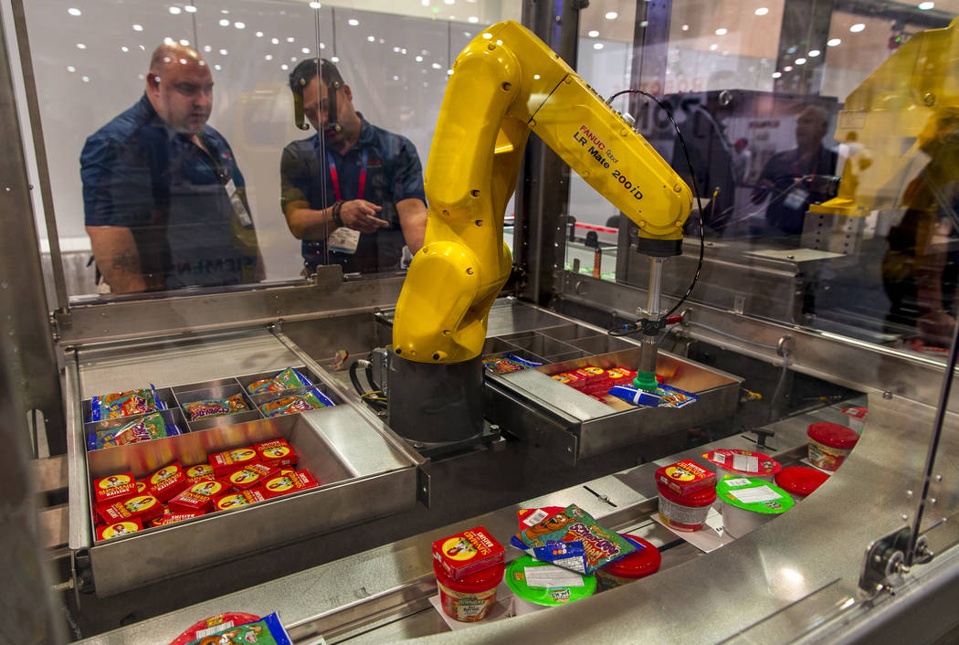 A robot with Bosch Packaging technology Inc. packs school lunches for kids through Blessings in ...