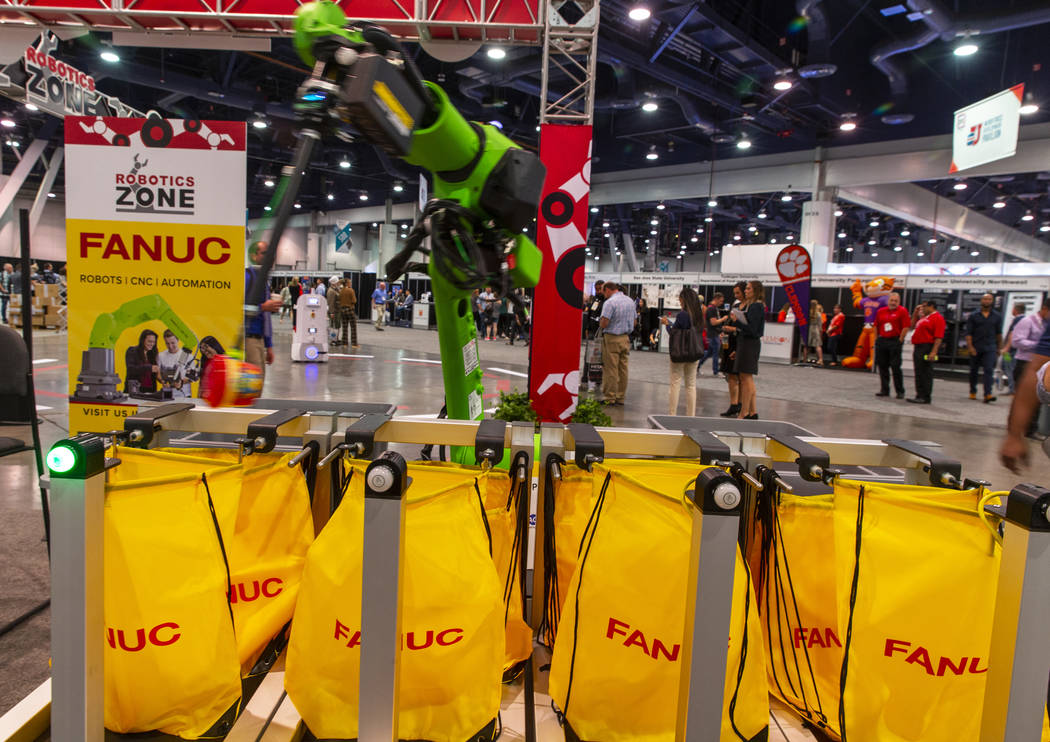 A robot from Fanuc packs school lunches for kids through Blessings in a Backpack at the PACK EX ...