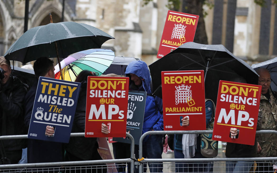 Anti-Brexit supporters gather in the rain outside the Supreme Court in London, Tuesday, Sept. 2 ...