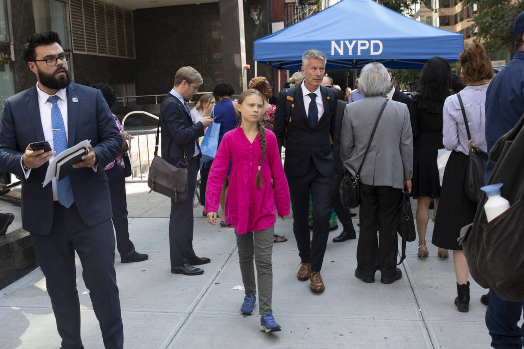 Environmental activist Greta Thunberg, center, of Sweden, walks with an entourage after passing ...