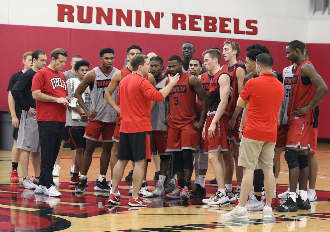 UNLV Rebels head coach T.J. Otzelberger, center, talks to his players after team's first basket ...