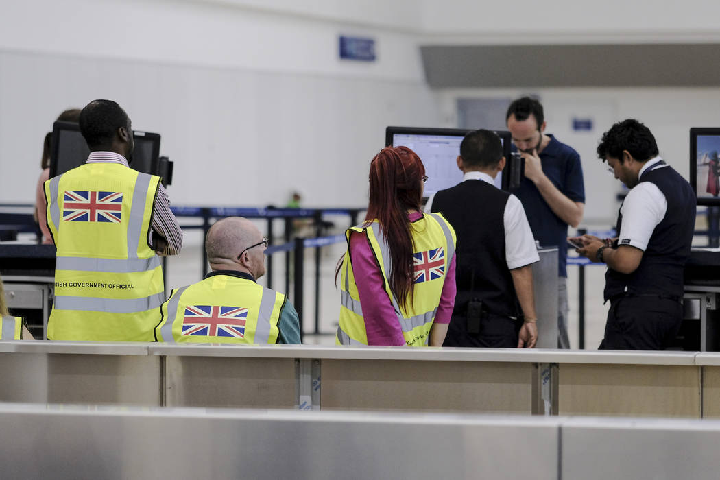 British government officials wait for stranded British passengers at the Cancun airport in Mexi ...