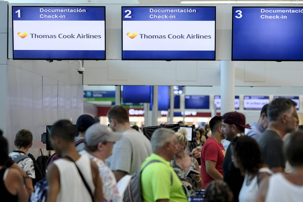 Stranded tourists line up in front of the Thomas Cook counter at the Cancun airport in Mexico, ...