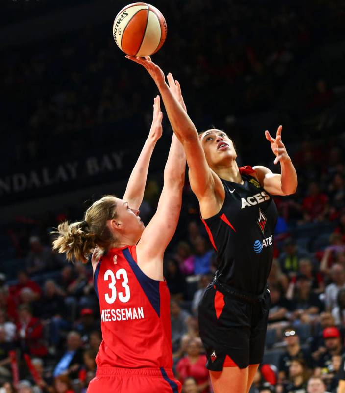 Las Vegas Aces' Dearica Hamby goes to the basket past Washington Mystics' Emma Meesseman (33) d ...