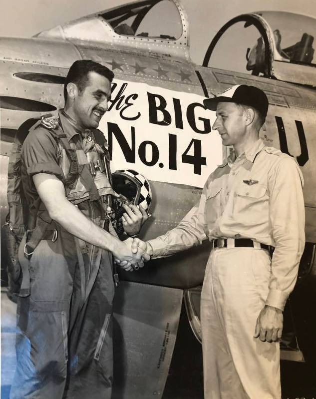 A young Henry Buttelmann receives a congratulatory handshake by Col. William C. Clark, acting c ...