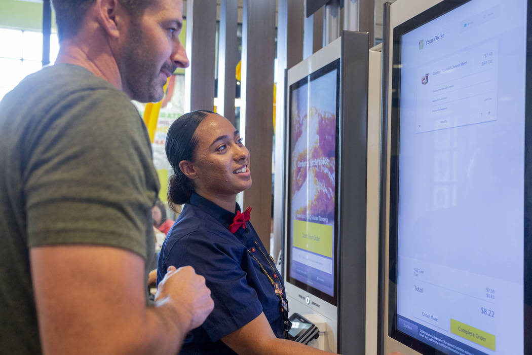 Costumer Todd Miller, Florida, left, and crew member Glenda Osorio order from a kiosk at the Mc ...