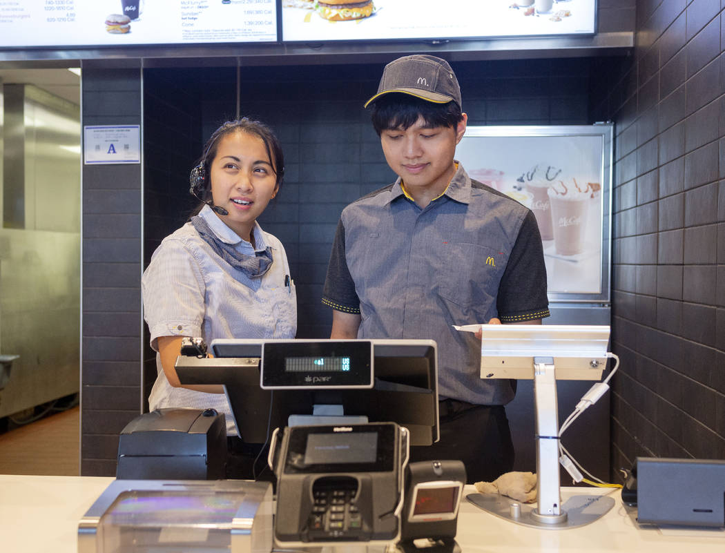 Shift manager Krizia Zamora, left, and crew member Jacob Zamora take a costumer's order at the ...