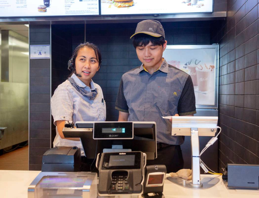 Shift manager Krizia Zamora, left, and crew member Jacob Zamora take a costumer's order at the ...