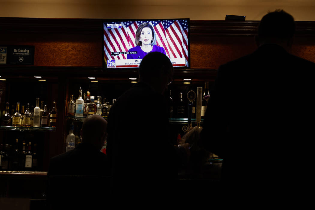 Journalists watch Speaker of the House Nancy Pelosi of Calif. announce a formal impeachment inq ...