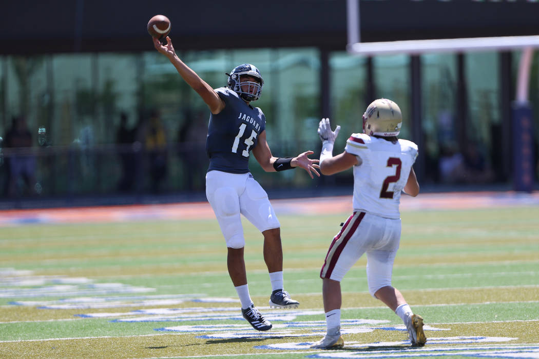 Desert Pines' Rjay Tagatases (15) throws the ball under pressure from Logan's Chris Shopbell (2 ...