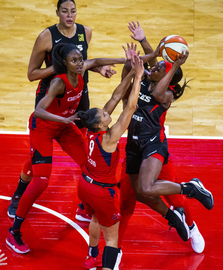 Las Vegas Aces guard Jackie Young (0, right) elevates for a shot attempt over Washington Mystic ...