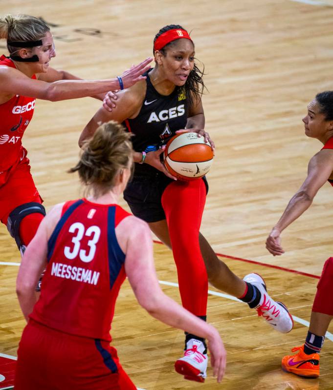 Las Vegas Aces center A'ja Wilson (22, center) attempts to drive through the Washington Mystics ...