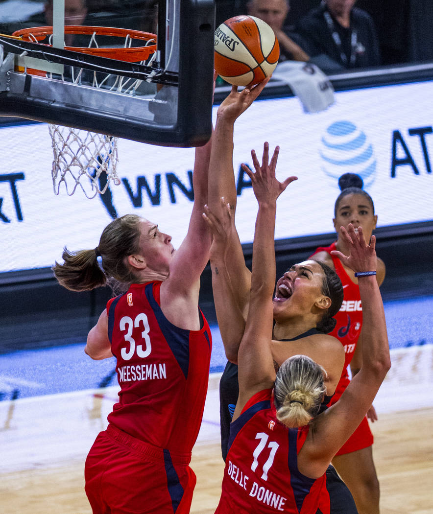 Las Vegas Aces center Liz Cambage (8, right) goes up for a shot attempt under tight defense by ...