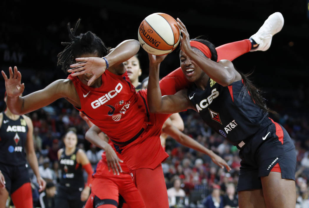 Washington Mystics' Ariel Atkins, left, fouls Las Vegas Aces' Jackie Young during the first hal ...