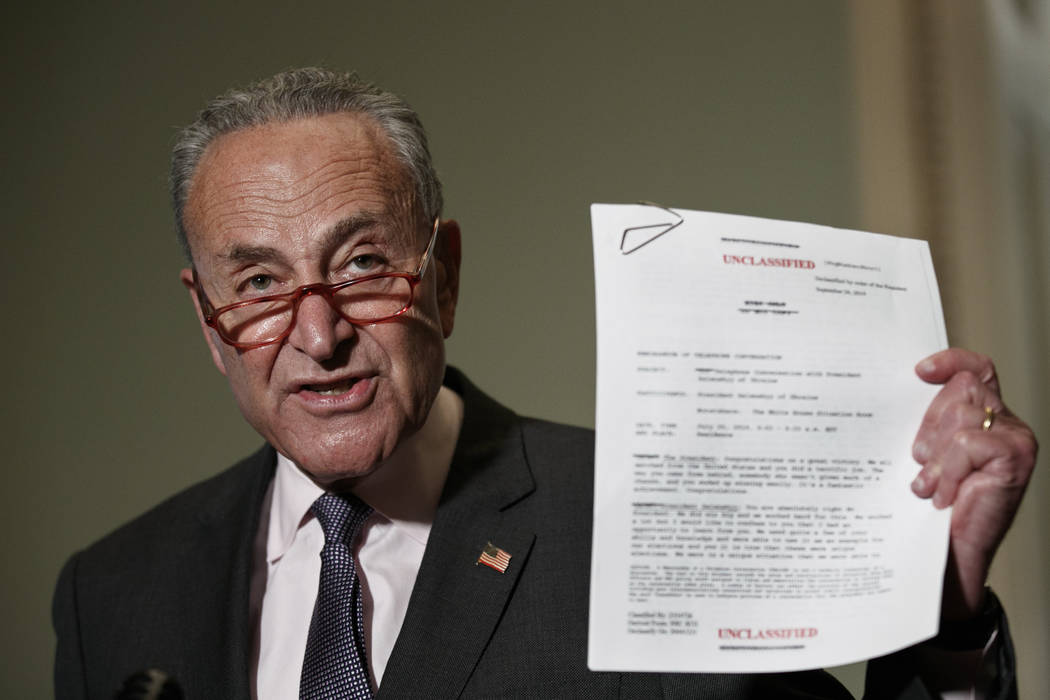 Senate Minority Leader Sen. Chuck Schumer of N.Y. holds up a copy of a White House released rou ...