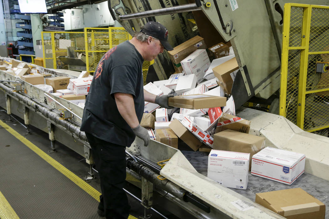 In this Thursday, Dec. 14, 2017 file photos, Steve Robino arranges packages on a conveyor belt ...