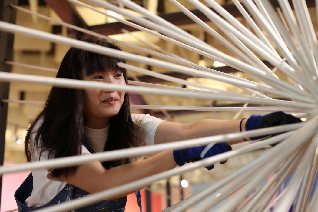 Artist Amanda Phingbodhipakkiya sets up the installation "There Are No Particles Only Fiel ...