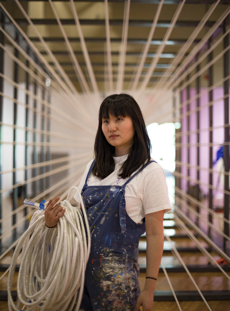 Amanda Phingbodhipakkiya, a neuroscientist-turned-artist, stands in front of one of her install ...