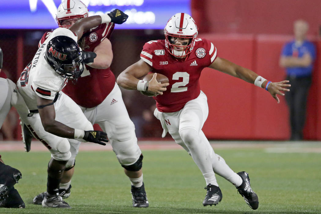 Nebraska quarterback Adrian Martinez (2) scrambles away from Northern Illinois defensive end Ca ...