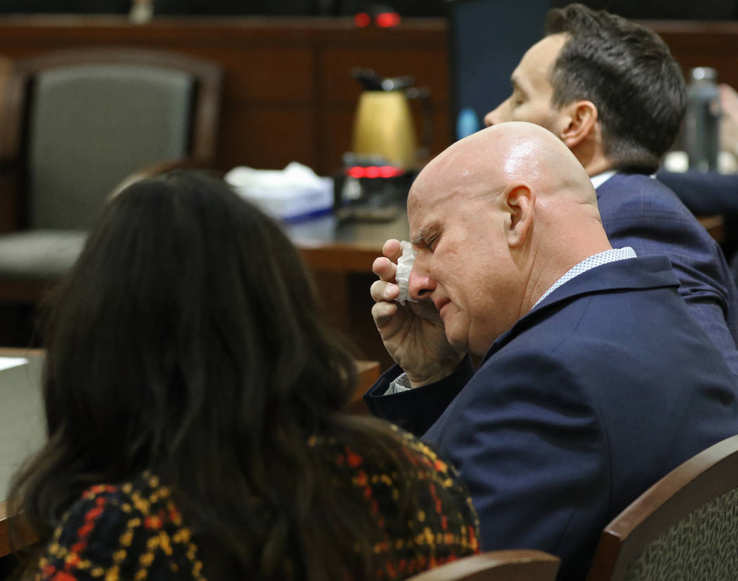 Las Vegas police Lt. James "Tom" Melton, middle, wipes tears from his eyes after he w ...