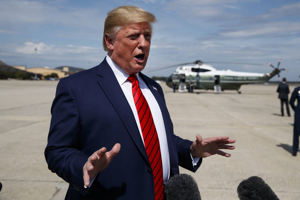 President Donald Trump talks with reporters after arriving at Andrews Air Force Base, Thursday, ...