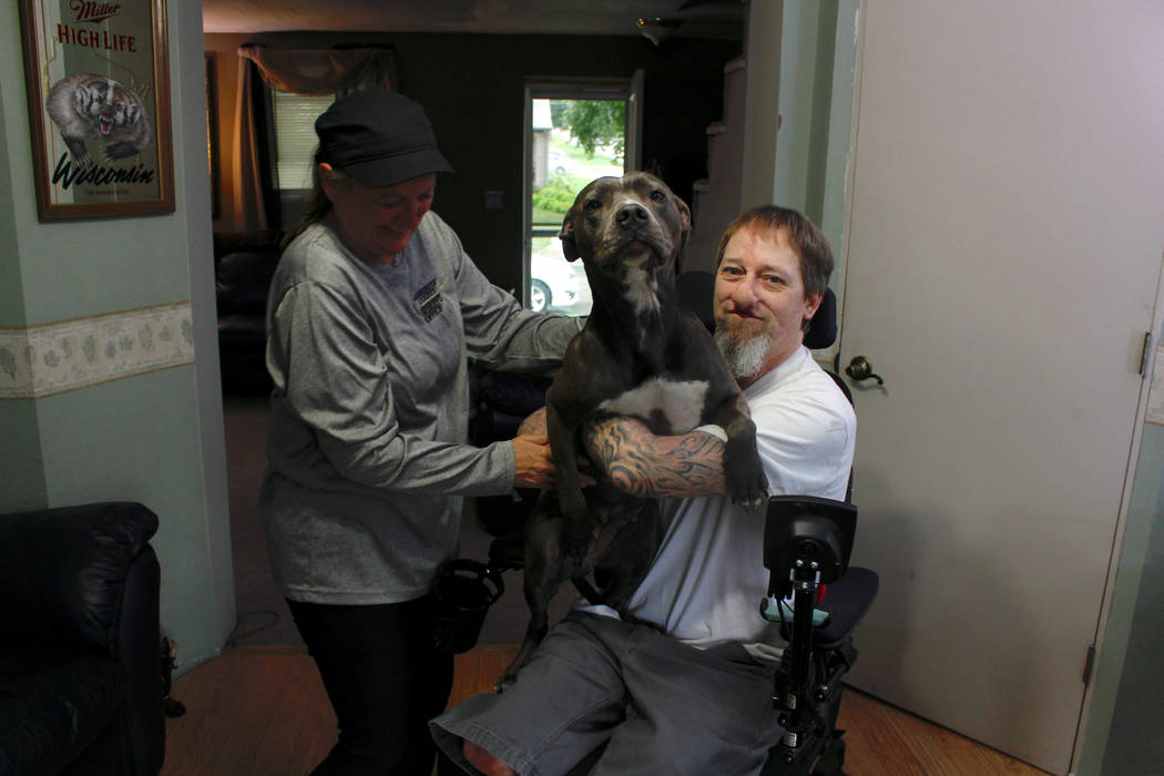 In this Aug. 16, 2019, photo, Greg Manteufel takes his dog Ellie from his wife Dawn Manteufel a ...