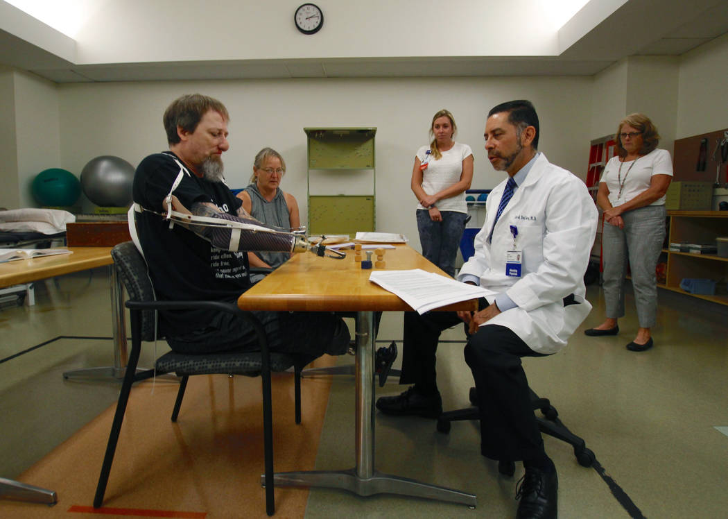 In this Aug. 19, 2019, photo, Greg Manteufel tries out a new prosthetic arm during occupational ...