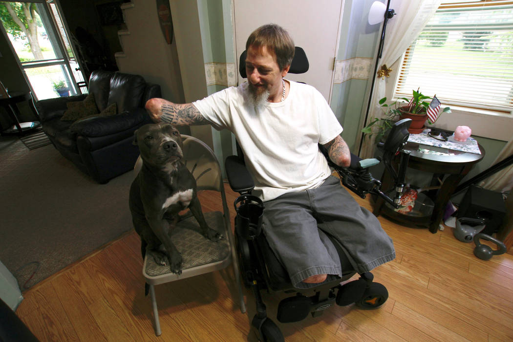 In this Aug. 16, 2019, photo, Greg Manteufel pets his dog Ellie at his home in West Bend, Wis. ...