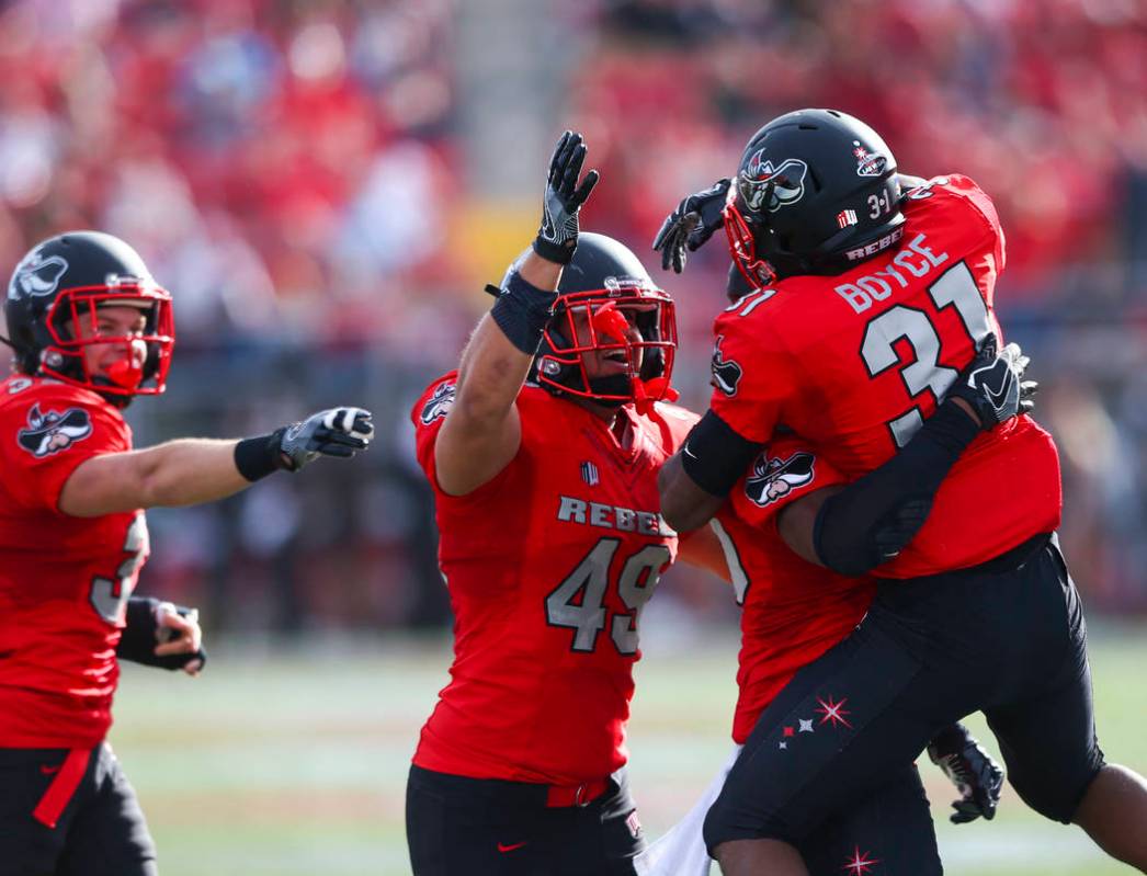UNLV players celebrate after gaining possession of the ball following a fumble by Wyoming durin ...
