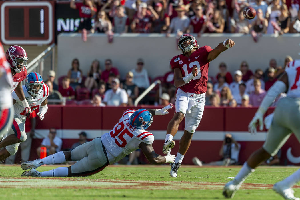 Alabama quarterback Tua Tagovailoa (13) throws under pressure from Mississippi defensive linema ...